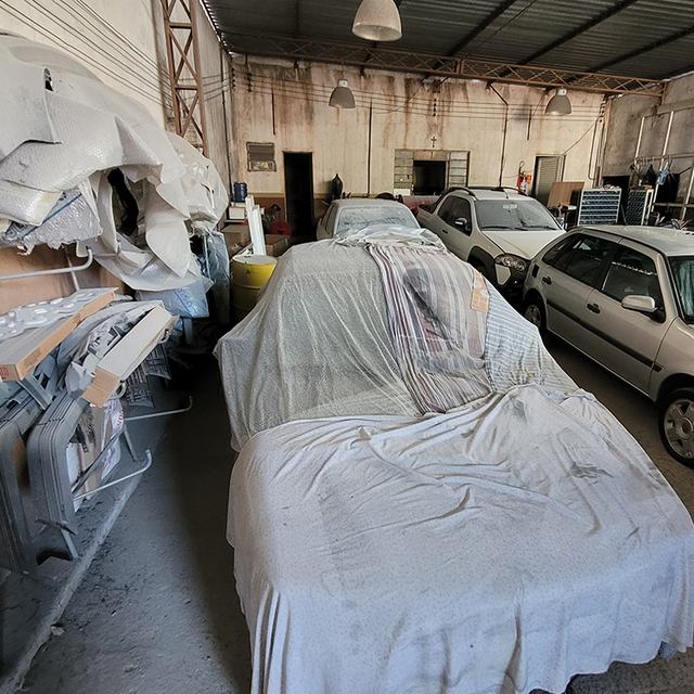 Carro coberto com capa protetora e para-choques preparados para pintura