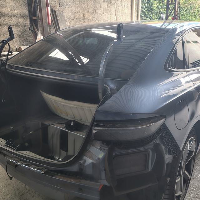 Sedã elétrico com o para-choque traseiro removido para reparo