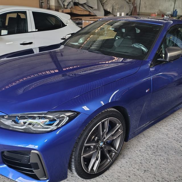 BMW cupê azul com a pintura brilhando na oficina